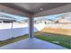 A covered patio with a view of a green lawn separated by a fence, enhancing outdoor living at 2447 Matterhorn Trl, Davenport, FL 33837