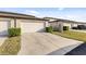 View of attached garage with large driveway and landscaping in front of the property at 2682 Mead Ave, St Cloud, FL 34771