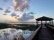 Lakeside gazebo view featuring calm waters and a picturesque sunset reflection on the water's surface at 2682 Mead Ave, St Cloud, FL 34771