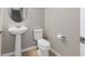 Elegant powder room with pedestal sink, modern toilet, and decorative mirror at 2682 Mead Ave, St Cloud, FL 34771