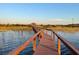 Picturesque wooden walkway and covered gazebo with a backdrop of calm water and community at 2682 Mead Ave, St Cloud, FL 34771