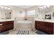 Elegant bathroom showcasing dual sinks, a triangular tub, and tile surround at 302 Vista Loop, Davenport, FL 33897