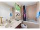 Neat bathroom with a shower and tub combination, decorated with fun superhero themed decor at 302 Vista Loop, Davenport, FL 33897