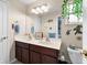 Bright bathroom features a double sink vanity, a large mirror, and a decorative hanging plant at 302 Vista Loop, Davenport, FL 33897