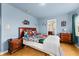 Comfortable bedroom featuring blue walls, wood floors, and an ensuite bathroom at 302 Vista Loop, Davenport, FL 33897