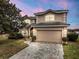 Beautiful two-story home with a spacious driveway and attached two-car garage at dusk at 302 Vista Loop, Davenport, FL 33897