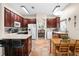 Open kitchen featuring dark wood cabinets, stainless steel appliances, and a view into the dining room at 302 Vista Loop, Davenport, FL 33897