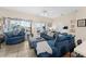 Bright living room with plush blue seating and views of the screened in pool at 302 Vista Loop, Davenport, FL 33897