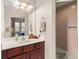 Bright bathroom features a wood vanity with white countertop and a glass shower enclosure at 302 Vista Loop, Davenport, FL 33897