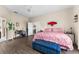Bright main bedroom features wood floors, ceiling fan, and a blue tufted bench at the foot of the bed at 302 Vista Loop, Davenport, FL 33897