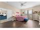 Bright main bedroom featuring wood floors, large windows, and a comfortable bed with a blue tufted bench at 302 Vista Loop, Davenport, FL 33897