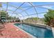 Backyard with a large screened-in pool, spa, brick patio, and outdoor seating area at 302 Vista Loop, Davenport, FL 33897