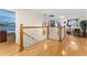 A second floor landing with hardwood flooring, wood railing and view of three bedroom areas at 302 Vista Loop, Davenport, FL 33897