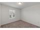 A carpeted bedroom with a neutral color scheme and natural light from a window at 3349 Vesara Dr, Davenport, FL 33837