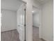 A carpeted hallway showcasing an open door to the bathroom at 3349 Vesara Dr, Davenport, FL 33837