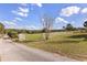 Long driveway leading to a vast property with white fence and green pastures against a blue sky at 36129 E El Dorado Lake Dr, Eustis, FL 32736