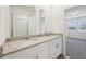 Elegant bathroom featuring double sinks with granite countertops, a shower and great natural lighting at 3845 Giorgio Dr, Winter Haven, FL 33884