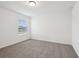 Minimalist bedroom featuring a plush carpet, a window with blinds, and a neutral color palette at 3845 Giorgio Dr, Winter Haven, FL 33884