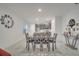 Well-lit dining area next to an island kitchen with a gray table, chairs, and tile flooring at 4057 Sagefield Dr, Harmony, FL 34773