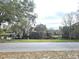 Scenic pond view from the street, lined with mature trees, offering privacy and a serene setting at 420 W Crystal Dr, Sanford, FL 32773