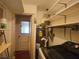 A compact utility room with a water heater, storage shelves, and access to the outside at 420 W Crystal Dr, Sanford, FL 32773