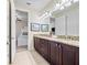 Well lit bathroom features double vanity with granite counters, tile floor, and adjacent room with a bunk bed at 431 Novi Path, Kissimmee, FL 34747
