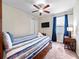 Comfortable bedroom featuring a ceiling fan, TV, and a bed with blue striped bedding at 431 Novi Path, Kissimmee, FL 34747
