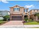 Charming two-story home with a brick driveway, attached two-car garage, and lovely landscaping at 431 Novi Path, Kissimmee, FL 34747