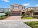 Charming two-story home with a brick driveway, attached two-car garage, and lovely landscaping at 431 Novi Path, Kissimmee, FL 34747