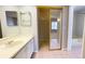 Bathroom with white vanity, large mirror, and mirrored closet doors leading into the bedroom at 4448 Pinebark Ave # 56-1, Orlando, FL 32811