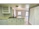 Kitchen with white cabinets, stainless steel appliances, tile floor, and breakfast bar overlooking the living room at 4448 Pinebark Ave # 56-1, Orlando, FL 32811