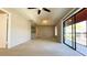 A spacious carpeted living room with a tray ceiling and a large sliding glass door to a screened balcony at 4448 Pinebark Ave # 56-1, Orlando, FL 32811