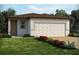 Charming single-story home featuring a neutral color palette, a two-car garage, and a well-manicured lawn at 4957 Kaia Ave, Winter Haven, FL 33884