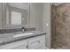 Bathroom featuring a modern vanity, granite countertop, and a tiled walk-in shower at 5055 Lake Howell Rd, Winter Park, FL 32792