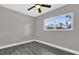 Cozy bedroom featuring a ceiling fan, natural light, and wood-look tile flooring at 5055 Lake Howell Rd, Winter Park, FL 32792