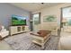 Comfortable living room featuring a large TV, neutral-toned furniture, and a patterned area rug at 5080 Longmeadow Park St, Orlando, FL 32811