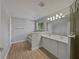 The elegant bathroom has dual sinks, wood-look tile floors, and a glass-enclosed shower at 662 Lake Dr, Altamonte Springs, FL 32701