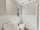 A simple bathroom showcases a classic white toilet, sink, and white-tiled wainscotting at 662 Lake Dr, Altamonte Springs, FL 32701