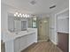 Bright bathroom featuring double sinks, modern lighting, a glass-enclosed shower, and wood-look floors at 662 Lake Dr, Altamonte Springs, FL 32701