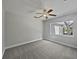 Neutral bedroom featuring a ceiling fan, gray carpet, and a big window providing natural light at 662 Lake Dr, Altamonte Springs, FL 32701
