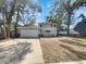 Charming two-story home with a large driveway, a two-car garage, and mature trees on a sunny day at 662 Lake Dr, Altamonte Springs, FL 32701