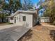 Back exterior view of a two-story house featuring neutral tones, a paved driveway, and a lush green landscape at 662 Lake Dr, Altamonte Springs, FL 32701