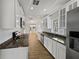 Well-lit kitchen featuring white cabinetry, granite countertops, stainless steel appliances, and wood-look floors at 662 Lake Dr, Altamonte Springs, FL 32701