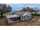 Lakefront home featuring a covered parking area, well-manicured landscaping, and serene water views at 9130 Laws Rd, Clermont, FL 34714