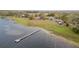 Expansive lakefront property featuring a private dock, lush green lawn, and multiple residential buildings at 9130 Laws Rd, Clermont, FL 34714