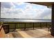 Wooden back porch overlooking a tranquil lake view with blue skies and fluffy clouds at 9130 Laws Rd, Clermont, FL 34714