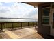 Cozy wooden back porch offers beautiful views of the serene lake and clear skies at 9130 Laws Rd, Clermont, FL 34714