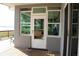 Welcoming back porch with clear glass door and windows offering scenic lake views at 9130 Laws Rd, Clermont, FL 34714