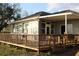 Home's back porch features wooden railings and access to the backyard at 9130 Laws Rd, Clermont, FL 34714