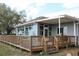 Charming back porch with a wooden deck, covered patio, and lush green surroundings at 9130 Laws Rd, Clermont, FL 34714
